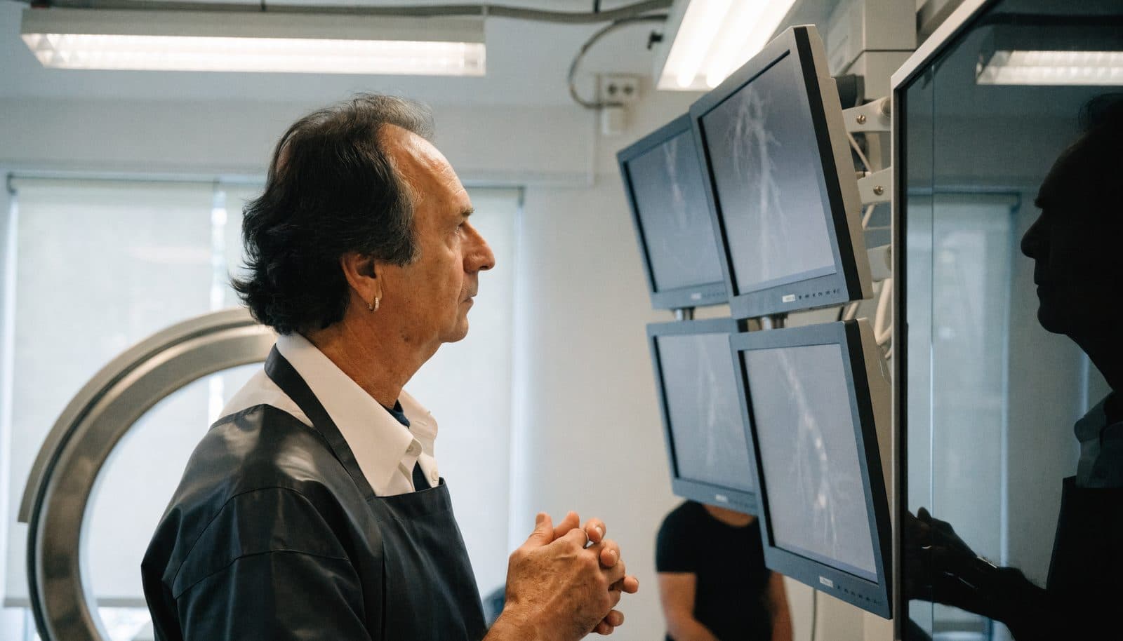 An interventional cardiologist reviewing coronary imaging in a catheterization lab