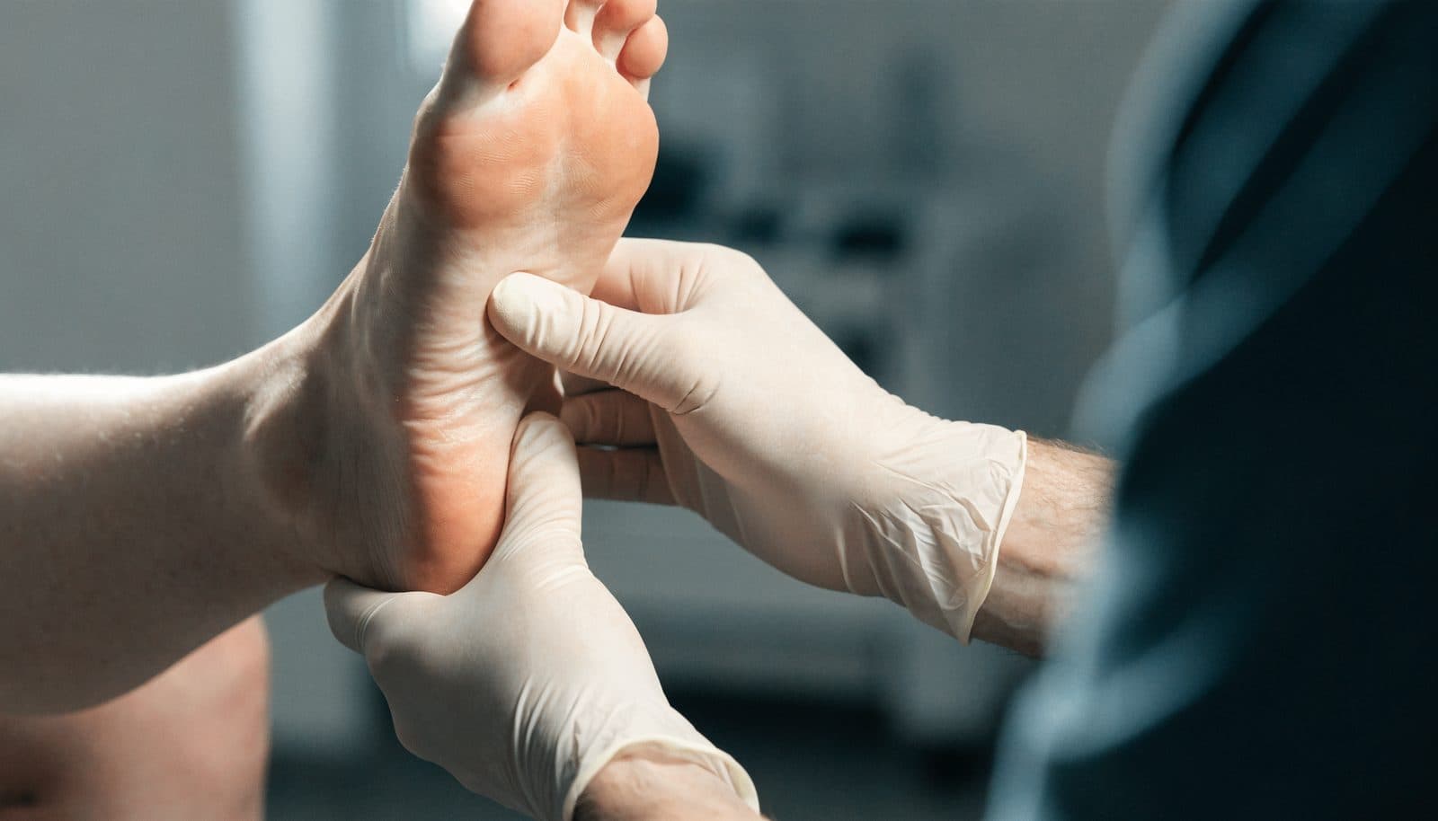 A clinician examining a patient's foot during a routine diabetic foot check